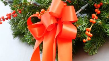 Kırmızı kurdele ve çilek kırmızı dalları ile Noel köknar çelenk. Geleneksel Noel ve Yılbaşı dekor