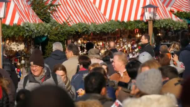 Nuremberg, Alemanha - 1 de dezembro de 2018: uma multidão de pessoas caminhando entre as barracas no mercado de Natal. Nurembergs mundialmente famoso mercado de Natal — Vídeo de Stock