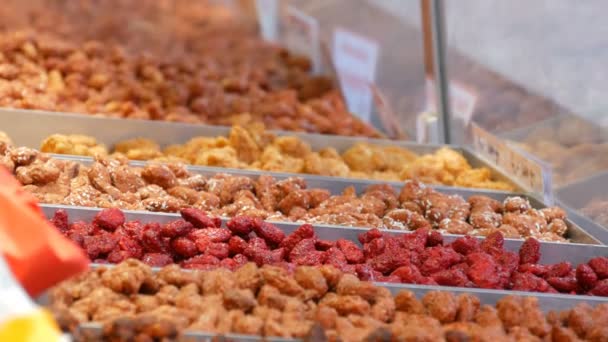 Variedad de dulces tostados tradicionales de Navidad Nueces en esmalte en el escaparate. Mercado de Navidad de Alemania — Vídeo de stock