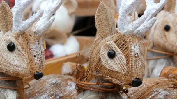 Hermosa decoración de Navidad en forma de figuritas de paja de ciervos en el mercado de Navidad — Vídeo de stock