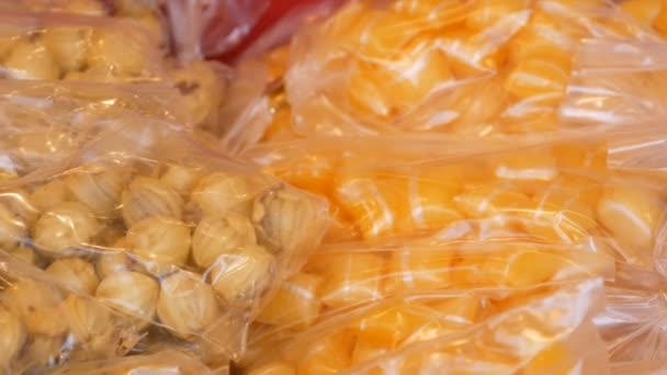 Vários pirulitos doces, doces embalados em sacos estão no balcão — Vídeo de Stock
