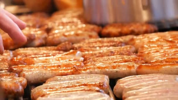 Un sacco di deliziose salsicce alla griglia Norimberga tedesco alla griglia in fila sul mercato di Natale, donna trasforma salsicce fritte — Video Stock