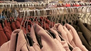 Yeni sıcak şık kazak Giyim Askıları asılı farklı renklerin çok sayıda alışveriş merkezi veya alışveriş merkezi depolar. Sıcak giysiler moda koleksiyonu.