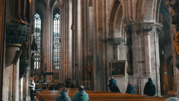 Norimberk, Německo – 1. prosince 2018: Inside view kostel St. Lorenz v Norimberku. Staré vysoké sloupy v středověkého kostela poblíž, které turisté pěšky — Stock video