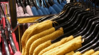 Çeşitli şık örme çok renkli kazak moda siyah askı bir giyim mağazasında alışveriş merkezi veya alışveriş merkezi içinde asılı