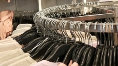 Çeşitli şık örme çok renkli kazak moda siyah askı bir giyim mağazasında alışveriş merkezi veya alışveriş merkezi içinde asılı olan büyük yuvarlak askı üzerinde görünümü kapatın