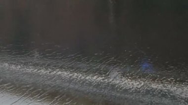 Yakın çekim shot yağmur damlaları ve çizgiler penceresinde hareketli otobüs ile şehir derin sonbaharda sokak od