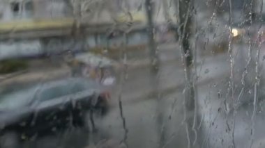 Yakın çekim shot yağmur damlaları ve çizgiler penceresinde hareketli otobüs şehrin derin sonbaharda sokak od