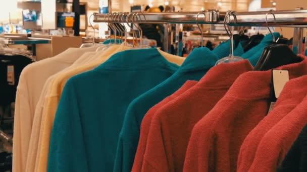 Nombre de peignoirs multicolores différents sur le cintre dans le magasin du centre commercial — Video