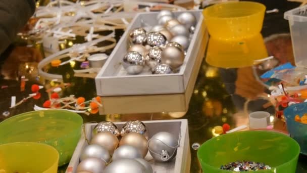 Nürnberg, Deutschland - 1. Dezember 2018: Kinder bereiten sich auf Weihnachten und Neujahr vor und basteln selbstgebastelte Weihnachtsbaumspielzeuge. Kinder haben Spaß in Einkaufszentrum oder Einkaufszentrum. — Stockvideo