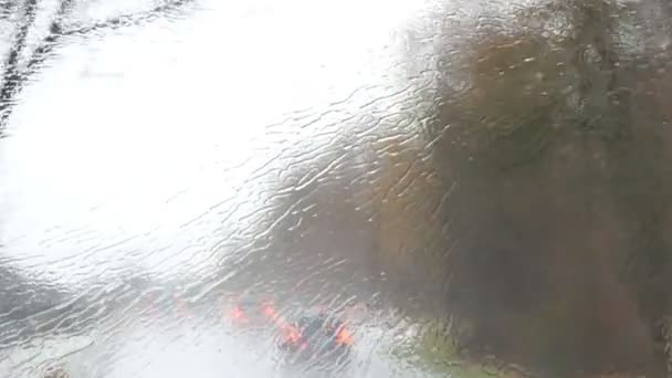 Primer plano de gotas de lluvia y rayas en la ventana od autobús en movimiento por la calle de la ciudad en otoño profundo — Vídeos de Stock