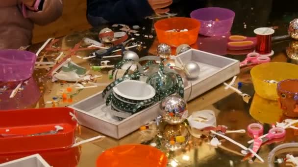 Нюрнберг, Германия - 1 декабря 2018 года: Дети готовятся к Рождеству и Новому году, создавая игрушки из елки ручной работы. Дети веселятся в торговом центре или торговом центре . — стоковое видео