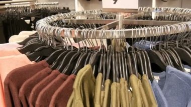 Çeşitli şık örme çok renkli kazak moda siyah Askı Giyim Mağazası bir alışveriş merkezi ya da alışveriş merkezi asılı olan bir büyük yuvarlak askı üzerinde görünümü kapatın