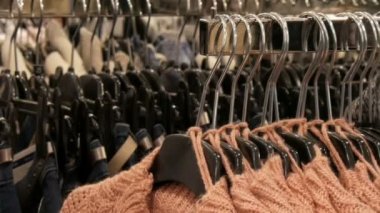 Yeni sıcak şık kazak Giyim Askıları asılı farklı renklerin çok sayıda alışveriş merkezi veya alışveriş merkezi depolar. Sıcak giysiler moda koleksiyonu.