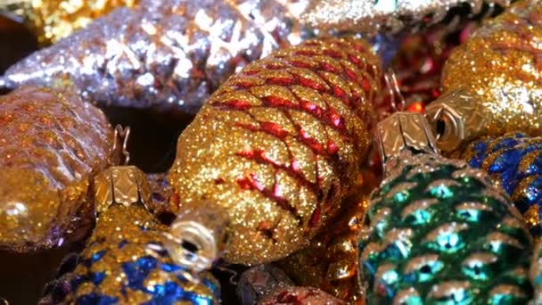 Красиві різдвяні прикраси у вигляді різнокольорових шишок, посипаних блискітками — стокове відео