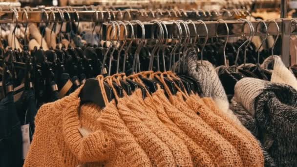 Nuremberg, Allemagne - 1er décembre 2018 : Un grand nombre de vêtements chauds pour femmes sont accrochés aux cintres et se trouvent sur les étagères d'un magasin de vêtements d'un centre commercial ou d'un centre commercial. Le problème du consumérisme — Video