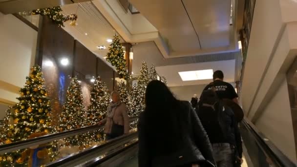 Nürnberg, Deutschland - 1. Dezember 2018: Die Kamera fährt in der Mall mit Rolltreppe an schön geschmückten Weihnachtsbäumen vorbei. Weihnachtsdekoration im Einkaufszentrum — Stockvideo