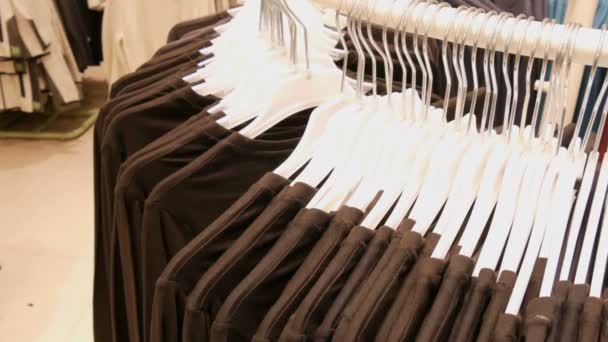 Kleren opknoping op hangers van een grote ronde staan in een kledingwinkel in mall of shopping center — Stockvideo