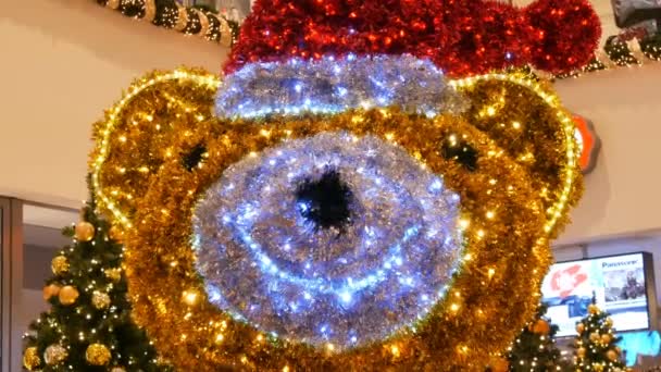 Nuremberg, Alemania - 1 de diciembre de 2018: Bellamente decorado con guirnaldas, un gran oso de Navidad con un sombrero rojo de Santa Claus en el centro comercial o centro comercial — Vídeo de stock