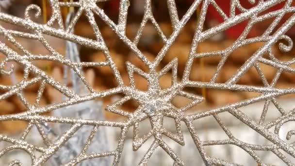 Nieuwjaar en Kerstmis decor. Een enorm mooie zilveren sneeuwvlok zwieren in de wind op kerstmarkt — Stockvideo