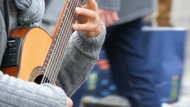 Nürnberg, Tyskland - 1 December 2018: Street gitarr professionella spelar skickligt spela akustisk gitarr i street. Gitarristen händer spelar en trä gitarr — Stockvideo