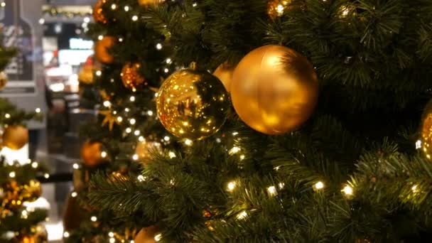 Núremberg, Alemania - 1 de diciembre de 2018: Árbol de Navidad bellamente decorado con grandes bolas de oro, estrellas, guirnaldas y nieve artificial están en el centro comercial en el fondo paseando a los compradores — Vídeo de stock