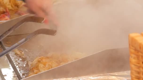 Comida callejera, papas fritas a la cebolla o repollo, girando cuchillas especiales. Comida tailandesa. Mercado de Navidad Alemania — Vídeos de Stock