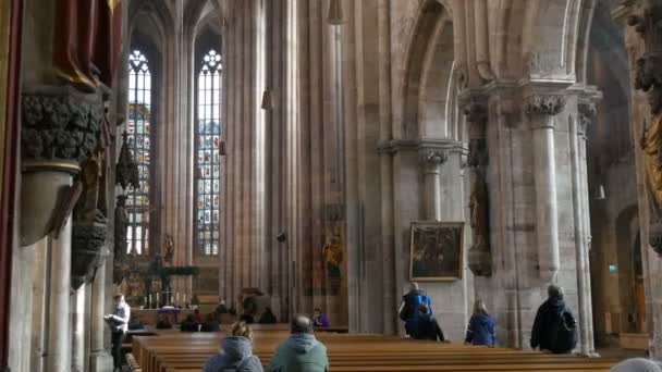 Nürnberg, Duitsland - December 1, 2018: binnen de mening van de kerk van St. Lorenz in Neurenberg. Oude hoge kolommen in middeleeuwse kerk in de buurt van die toeristen lopen — Stockvideo