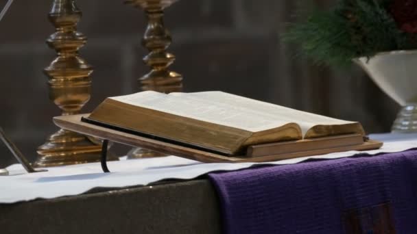 Великая книга священника лежит на алтаре в старой католической церкви — стоковое видео