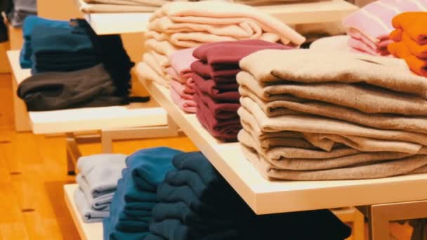 Nürnberg, Németország - 2018. December 3.: Elegáns ruhákat rakott a polcok, fogasok, a bevásárlóközpontban egy ruhaüzlet sorban. — Stock videók