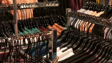 Şık elbise askıları bir alışveriş merkezinde bir giyim mağazası satırındaki asılı.