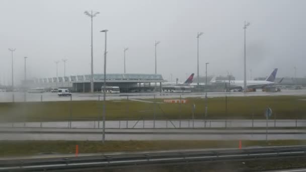 München, Duitsland - December 2, 2018: Weergave van München Airport met geparkeerde vliegtuigen vanuit het raam van een bus die snel langs de snelweg beweegt. — Stockvideo