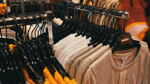 Nuremberg, Alemanha - 3 de dezembro de 2018: roupas elegantes penduradas em filas em cabides em uma loja de roupas em um shopping . — Vídeo de Stock