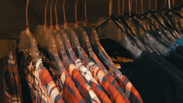 Νυρεμβέργη, Γερμανία - 3 Δεκεμβρίου 2018: Μοντέρνα ρούχα που κρέμονται στη γραμμή στις κρεμάστρες σε ένα κατάστημα ιματισμού σε ένα εμπορικό κέντρο. — Αρχείο Βίντεο
