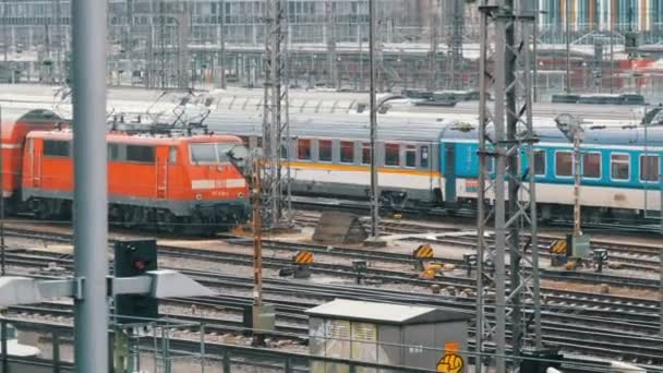 Múnich, Alemania - 2 de diciembre de 2018: Trenes ferroviarios en los que los trenes viajan bajo la lluvia cerca de la estación principal de tren en Múnich . — Vídeos de Stock