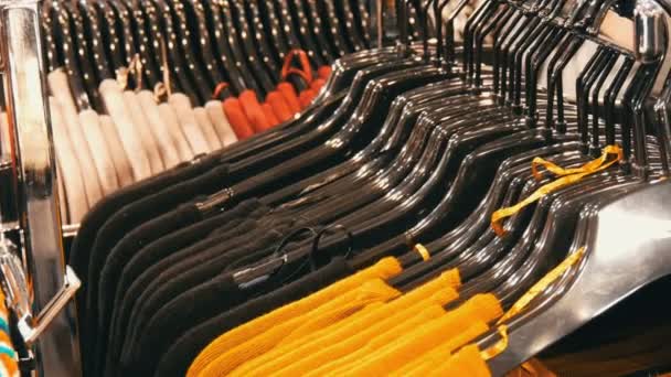 Nürnberg, Duitsland - 3 December 2018: Stijlvolle kleren opknoping in rij op hangers in een kledingwinkel in een winkelcentrum. — Stockvideo