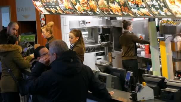 Munich, Allemagne - 2 décembre 2018 : La file d'attente des personnes qui restent avant le comptoir et veulent acheter de la nourriture au célèbre fast-food McDonalds sur Karlsplatz Stachus . — Video