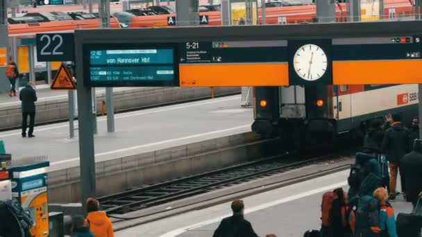 Múnich, Alemania - 2 de diciembre de 2018: La pizarra electrónica de los trenes que llegan y salen está escrita en alemán. Ronda de la estación de reloj en la estación principal de tren en Munich . — Vídeos de Stock