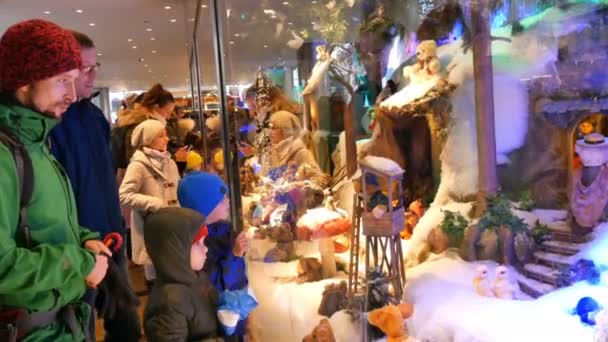 ミュンヘン, ドイツ - 2018 年 12 月 2 日: クリスマスの祝日のためだけ開きますマリエン広場に動くオモチャで有名なミュンヘンのショーケース。大人と子供たちの群衆はそれを見てください。. — ストック動画