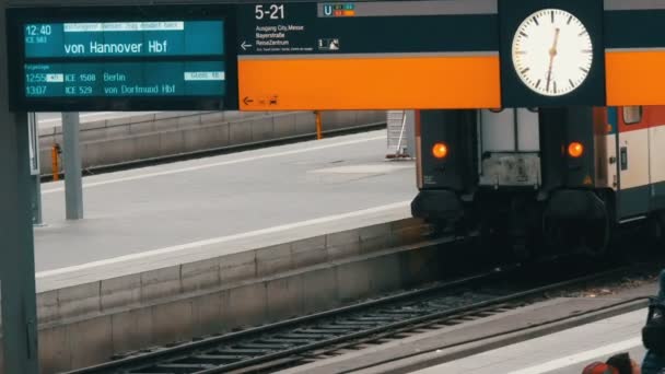 Munich, Allemagne - 2 décembre 2018 : Le tableau électronique des trains d'arrivée et de départ est écrit en allemand. Autour de la station d'horloge à la gare principale de Munich . — Video