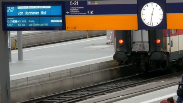 München, Tyskland - 2 December 2018: Elektroniska styrelsen ankommande och avgående tåg är skriven på tyska. Dygnet runt stationen vid centralstationen i München. — Stockvideo