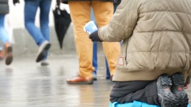 Münih, Almanya - 2 Aralık 2018: Kadın dilenci onun elinde bir fincan ile sadaka için dizlerinin üzerinde sorar.