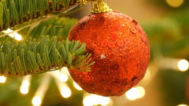 Hermosa bola de juguete elegante árbol de Navidad de color rojo cuelga en el árbol de Navidad vista de cerca. Año Nuevo y decoración de Navidad . — Vídeos de Stock