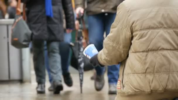 München, Tyskland - 2 December 2018: Kvinna tiggare med en kopp i handen ber om allmosor på knä — Stockvideo