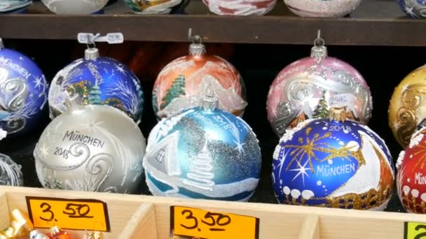 Diverses belles boules et jouets de Noël pour décorer le sapin de Noël sur le comptoir du marché. Inscription en allemand — Video