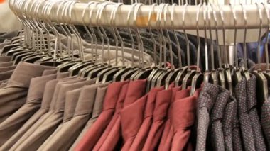 Satır erkek giyim mağazası alışveriş merkezinde büyük bir askı üzerinde çeşitli moda erkek gömlek