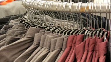Satır erkek giyim mağazası alışveriş merkezinde büyük bir askı üzerinde çeşitli moda erkek gömlek.