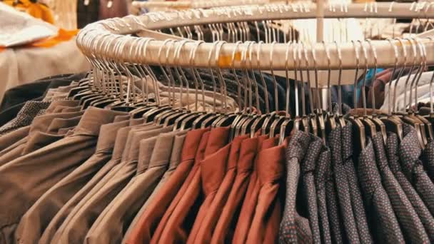 Rij van verschillende modieuze heren shirts op een enorme hanger in de mens kledingwinkel in het winkelcentrum. — Stockvideo