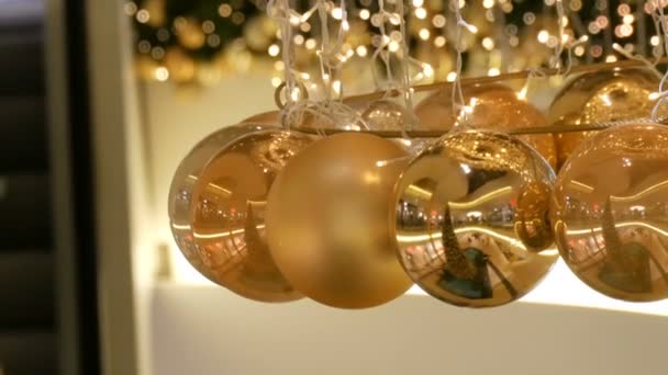 Χριστουγεννιάτικα Στεφάνια Φώτα Και Μπάλες Από Χρυσό Χρώμα Φόντο Θολή — Αρχείο Βίντεο