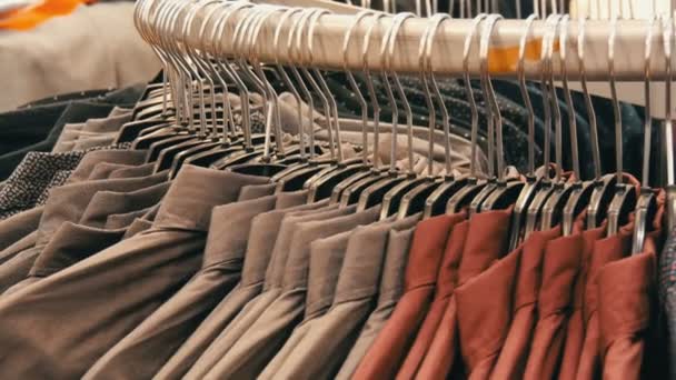 Fila di varie camicie alla moda da uomo su un enorme appendiabiti nel negozio di abbigliamento da uomo nel centro commerciale . — Video Stock